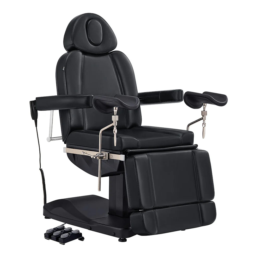 All-black electric medical and esthetician chair featuring adjustable stirrup armrests, extendable leg rests, and a multi-switch foot pedal.